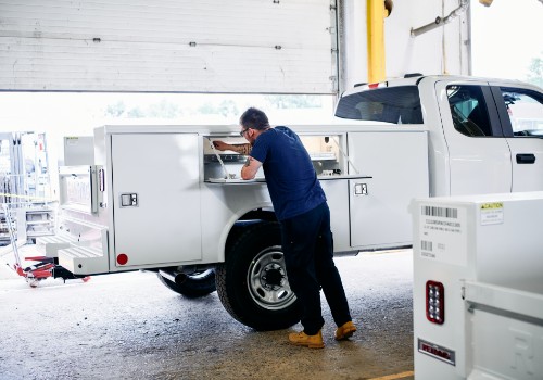A technician working on a compartment of a service body